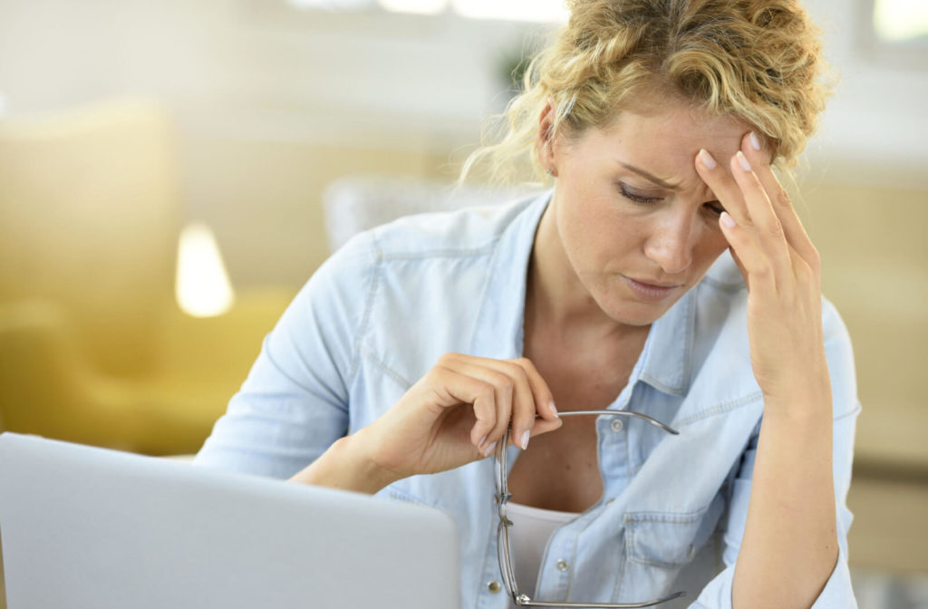 Woman with a laptop having a headache due to digital eye strain