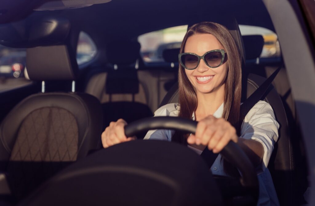 A woman in the car wearing sunglasses while driving to help reduce glare and eye fatigue