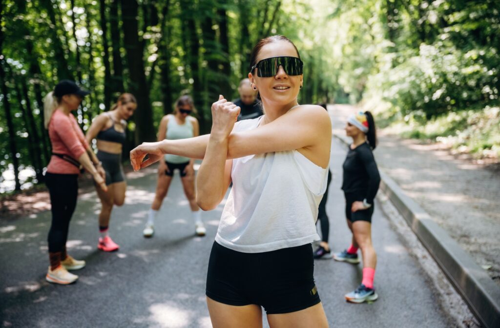 A person outside, warming up for a run while wearing sport specific eyewear.