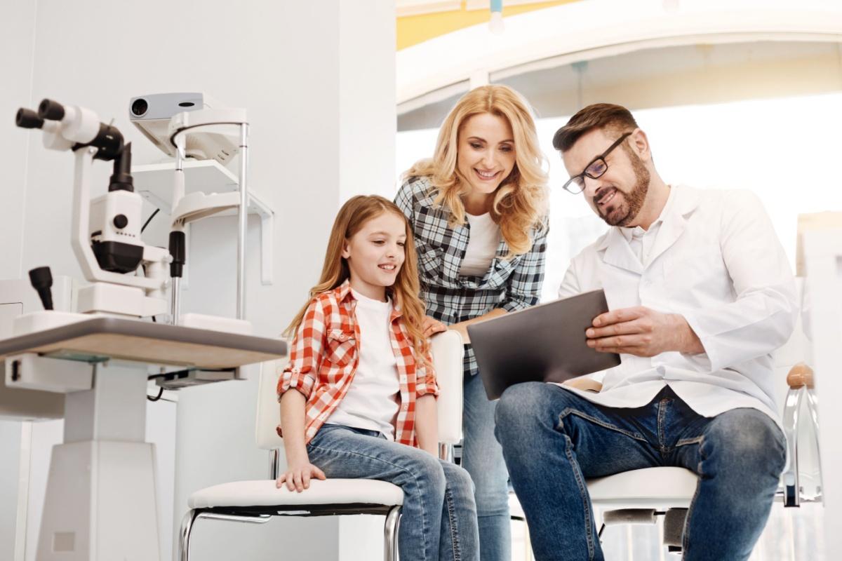 A family discussing family health history with their optometrist during an eye exam.